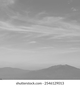 A stunning mountain landscape under a clear sky, captured in black and white to emphasize the rugged terrain and serene atmosphere, highlighting the contrast between light and shadow. - Powered by Shutterstock