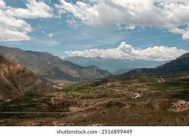 Stunning mountain valley landscape with fluffy clouds, lush greenery, and towering peaks, perfect for peaceful exploration - Powered by Shutterstock