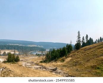 Stunning natural landscape of Yellowstone National Park featuring vibrant thermal springs, rugged mountains, lush forests, and serene rivers. Perfect for travel, nature, and outdoor adventure themes. - Powered by Shutterstock