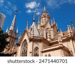 Stunning neo-Gothic Catholic temple with pointed arches, tall spires, stained glass windows, and intricate architectural details under a bright blue sky in Belo Horizonte, Minas Gerais, Brazil