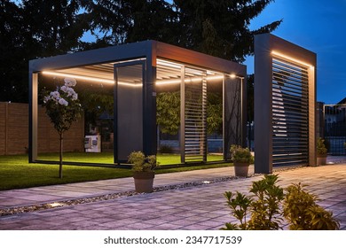 Stunning night photo of a luxurious outdoor pergola, boasting exquisite design with LED panels and lighting. Fully controllable via mobile, set in the garden of an upscale family home.