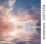 Stunning nightscape: dramatic cloud formations dominate twilight sky, radiating mesmerizing interplay of vibrant pigments over expansive ocean. Serene body of water mirrors celestial display, creating seamless blend of vivid lavender and pink hues that fade into soft blues, evoking tranquil mood perfect for wellness campaigns. Golden beams from setting sun slice through cumulus formations, casting warm glow across shimmering surface where gentle ripples add soothing texture and depth. Ethereal composition embodies contemplative atmosphere with soft, diffused lighting that enhances dreamlike quality of nautical vista. This relaxing ambient imagery provides ample negative space in skylight for text overlays, making scene ideal for meditation apps or spa brochures. Radiant color palette showcases nature