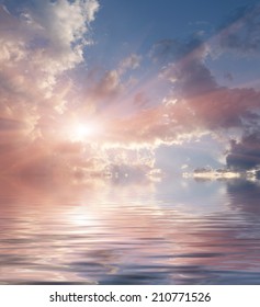 Stunning nightscape: dramatic cloud formations dominate twilight sky, radiating mesmerizing interplay of vibrant pigments over expansive ocean. Serene body of water mirrors celestial display, creating seamless blend of vivid lavender and pink hues that fade into soft blues, evoking tranquil mood perfect for wellness campaigns. Golden beams from setting sun slice through cumulus formations, casting warm glow across shimmering surface where gentle ripples add soothing texture and depth. Ethereal composition embodies contemplative atmosphere with soft, diffused lighting that enhances dreamlike quality of nautical vista. This relaxing ambient imagery provides ample negative space in skylight for text overlays, making scene ideal for meditation apps or spa brochures. Radiant color palette showcases nature's transition during dusk moments, capturing blissful serenity of oceanic horizon.
