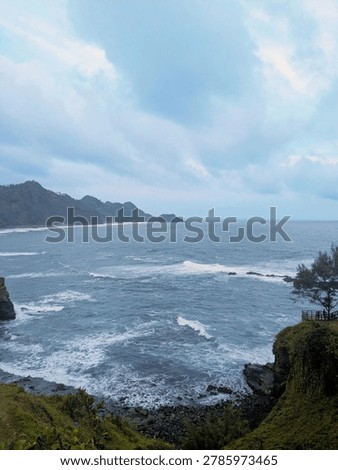 Stunning ocean wave patterns hitting the rocky shore of Menganti Beach in Kebumen, Indonesia