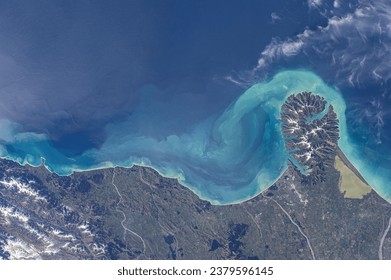 Stunning oceanfront where steep slopes meet turquoise shores. Satellite image of currents continuing along the coast with clouds.  Elements of this image furnished by NASA. - Powered by Shutterstock