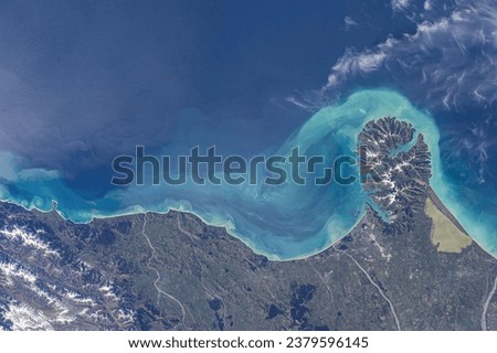 Stunning oceanfront where steep slopes meet turquoise shores. Satellite image of currents continuing along the coast with clouds.  Elements of this image furnished by NASA.