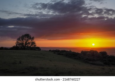 Stunning orange sunset looking out from Butser Hill, the highest point on the chalk ridge of the South Downs, Hampshire, UK - Shutterstock ID 2168760227