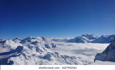 Stunning panorama from Mont-Fort, Verbier, Valais, Switzerland on a clear bright winter day. Rosablanche, sea of clouds over Val de Bagnes, Grand Combin and Combin de Corbassière.