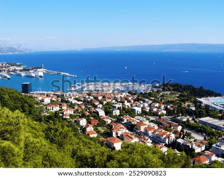 A stunning panorama of Split, showcasing the vibrant marina and bustling port, with the open sea stretching beyond and the picturesque island of Brač in the background.