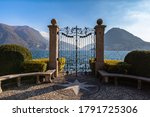 Stunning panorama view of Lugano Lake with Monte San Salvatore in background from gate of Cancello sul Lago di Lugano in Parco Ciani park on sunny autumn day, Canton of Ticino, Switzerland