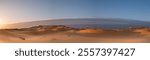 Stunning panoramic photograph of the winter sunrise in the incredible dunes of the Sahara Desert in Merzouga in Morocco, North Africa