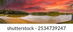 	
a stunning panoramic shot of the silky brown waters of the Chattahoochee river surrounded by green and autumn colored trees with powerful clouds at Sweetwater Creek State Park in Lithia Springs GA	