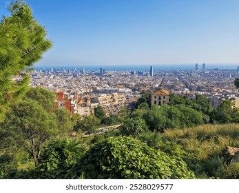 Stunning panoramic view of Barcelona from the hills, with iconic city landmarks, lush greenery, and vibrant purple flowers growing among weathered bricks in the foreground - Powered by Shutterstock