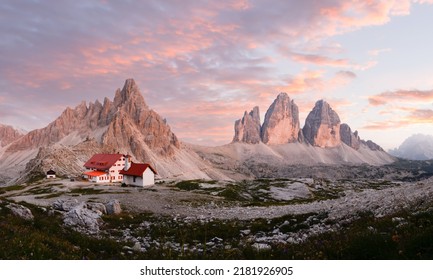 Stunning panoramic view of the Three Peaks of Lavaredo, (Tre cime di Lavaredo) Mount Paterno and a refuge during a beautiful sunset. - Shutterstock ID 2181926905