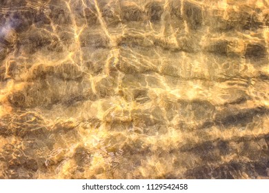 Stunning patterns created by small waves and sun rays on a clear day