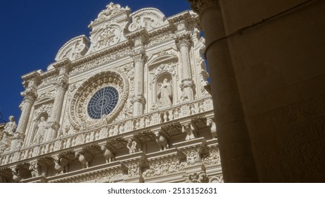 A stunning photo of the ornate facade of the baroque basilica in lecce, puglia, italy, showcasing intricate stone carvings under a clear blue sky. - Powered by Shutterstock