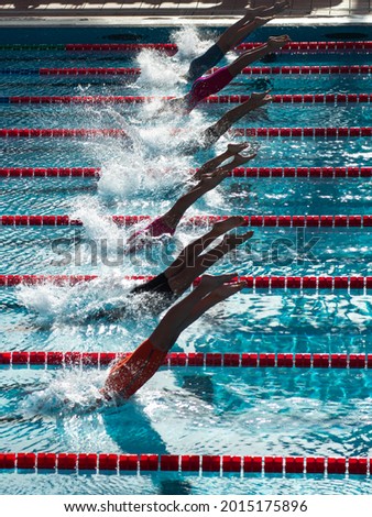 Stunning picture of the synchronization of divers diving in the swimming pool