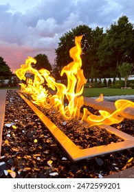 Stunning poolside gas fire pit filled with black glass compliments the in-ground, built in pool at sunset. Provides the perfect amount of warmth for entertaining and can be enjoyed all year round. 