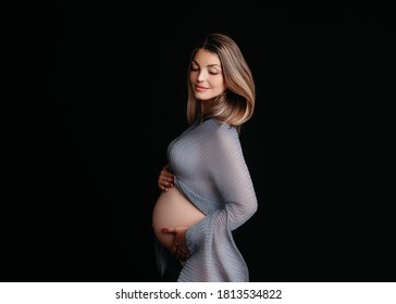 Stunning Pregnant Woman - Maternity Photography Of A Beautiful Young Expecting Mother To Be On A Black Background, Studio Photography