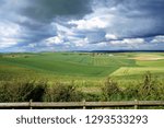 Stunning reflection of sunlight while rain clouds forming above the inland of Calais with green fields and meadows