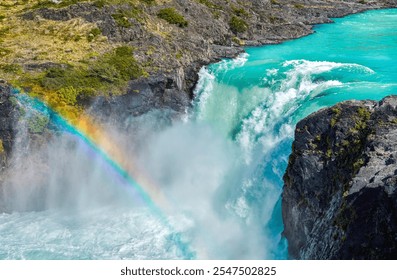 The stunning Salto Grande waterfall in Chilean Patagonia cascades powerfully amidst turquoise waters, rugged cliffs, and vibrant rainbows, offering a breathtaking display of nature's grandeur. - Powered by Shutterstock