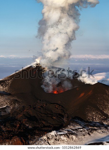 Stunning scenery eruption volcano landscape of\
Kamchatka Peninsula: aerial view of active Tolbachik Volcano,\
erupting fountain of red hot lava from cinder cone of volcanic\
crater. Russian Far\
East