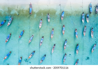 Stunning summer landscape. Aerial view of fishing long tail boat group in turquoise Andaman sea near beautiful white beach at Koh Lipe or Lipe island, Satun, Southern Thailand. Shot from drone