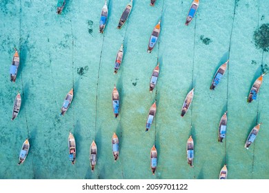Stunning summer landscape. Aerial view of fishing long tail boat group in turquoise Andaman sea at Koh Lipe or Lipe island, Satun, Southern Thailand. Shot from drone