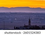 A stunning sunrise aerial view of Seville showcases the Corazon de Jesus monument and distant hills of Moron.