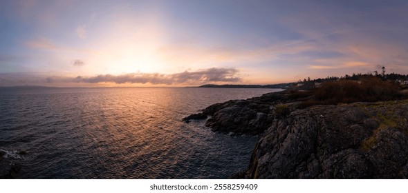 A stunning sunrise over the rocky coastline of Victoria, Vancouver Island, BC, Canada. The serene view showcases the beauty of the ocean meeting the horizon at dawn. - Powered by Shutterstock