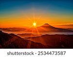 A stunning sunrise paints the sky with soft hues of orange, pink, and gold as the first light of day breaks. The sun slowly rises above the horizon, casting a peaceful glow over the tranquil landscape