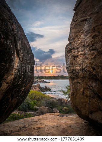 Stunning Sunset In Between Two Huge Rocks on the Beach at Whiskey Point, Arugam Bay, Sri Lanka