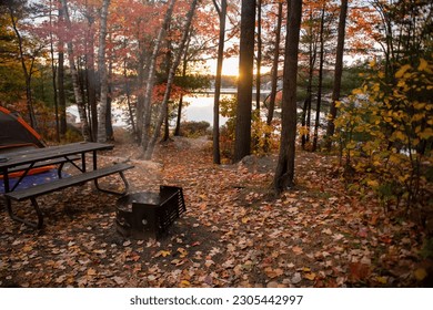 Stunning sunset from a camping site with beautiful fall foliage by a lake - Powered by Shutterstock