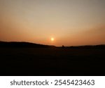 Stunning Sunset Over a Field in Turner Valley, Diamond Valley, Alberta, Canada – Vibrant Orange Sky and Tranquil Landscape