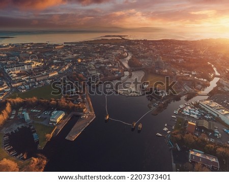 Stunning sunset over Galway city and river Corrib. Ireland. Calm and subtle colors. Sun flare, Aerial view. Burren and Galway bay in the background.