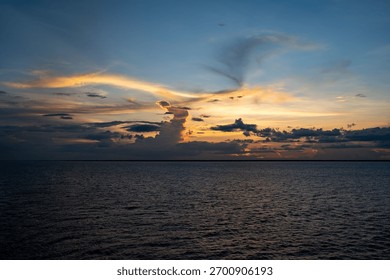 Stunning sunset over the ocean with dramatic clouds and a colorful sky, capturing the serene beauty of nature.