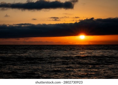 Stunning sunset over the ocean with dramatic clouds and vibrant colors