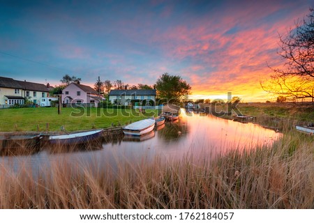 Stunning sunset over the village green and boats on the river at West Somerton in the Norfolk Broads