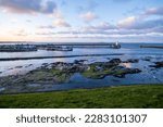 Stunning sunset at Seahouses Harbour on the beautiful Northumberland Coast, with a view of the lighthouse and the distant Farne Islands.