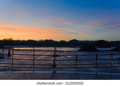 Stunning Sunset Sky Over An Empty Building Site Closed Off With Steel Gates