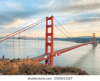 A stunning sunset view of the Golden Gate Bridge facing toward San Francisco. The iconic landmark is beautifully silhouetted against the evening sky, vibrant sunset colors and the city's skyline - Powered by Shutterstock