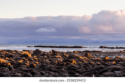 Stunning sunset view of the rocky shoreline in Port Renfrew, Vancouver Island. The scene captures the beauty of nature with dramatic clouds and serene ocean waves. - Powered by Shutterstock