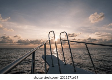 A stunning sunset view while floating on a boat in the ocean.