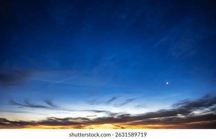 A stunning transition from sunset to night with vibrant colors, scattered stars, and a bright celestial object near the horizon.