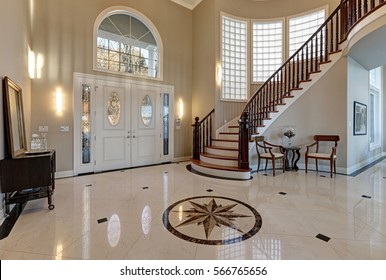 Stunning two story entry foyer with lots of space boasts marble mosaic tile floor, front door framed with arch window and sidelights, grand staircase with glossy wood curved banister. Northwest, USA