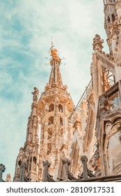 Stunning vertical composition capturing the elaborate white marble gothic architecture, detailed sculptures, and soaring spires of the Duomo di Milano reaching towards the heavens.