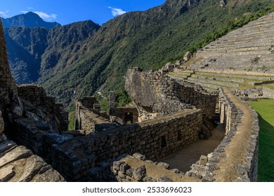 A stunning view of the ancient Inca ruins of Machu Picchu with terraced fields and mountainous backdrop under a clear blue sky. - Powered by Shutterstock