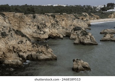 Stunning view of coastal rock formations and sea arches in Portimao, Portugal. The rugged cliffs and scattered sea stacks create a dramatic and picturesque seascape. - Powered by Shutterstock