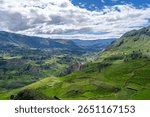 A stunning view of Colca Canyon with dramatic cliffs, lush greenery, and a clear blue sky