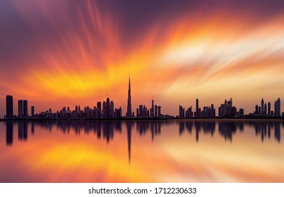 Stunning view of Dubai skyline  with warm Pastel Sunset Clouds and reflection 